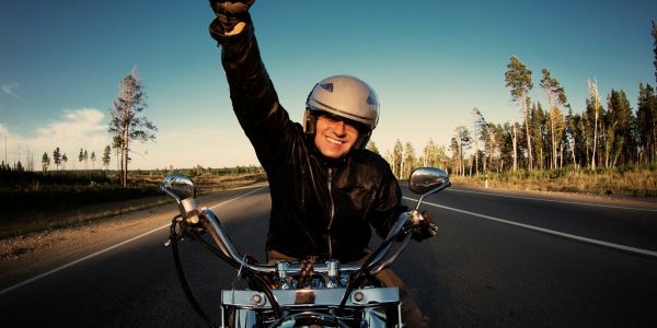 Jubilant man on a motorbike, raising a fist