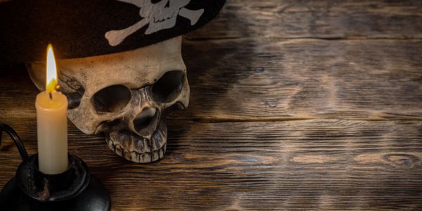 Pirate skull and a candle on a wooden table