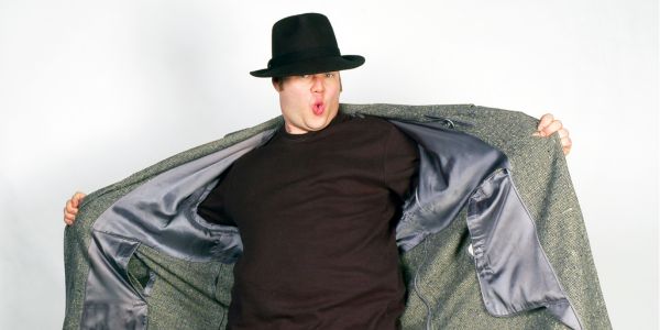 Young man jokingly opens his raincoat; a "flasher".