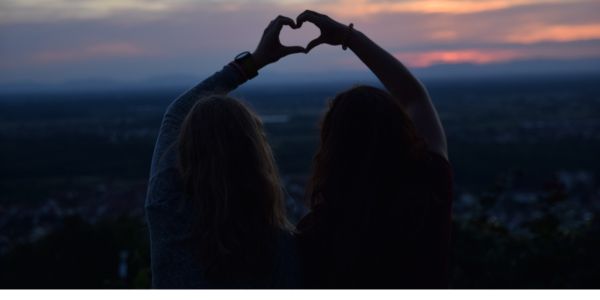 Friends making the "love" sign with their fingers